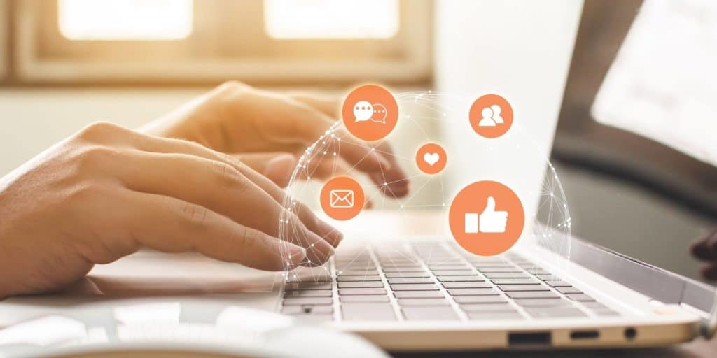 Typing on laptop with Instagram engagement icons.